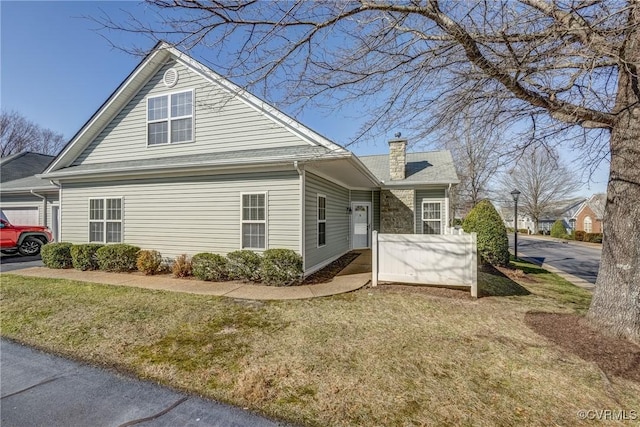 view of side of property featuring a yard and a chimney