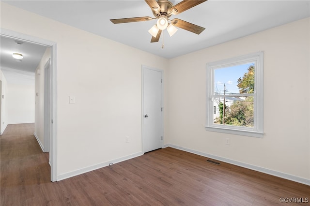 empty room with visible vents, baseboards, ceiling fan, and wood finished floors