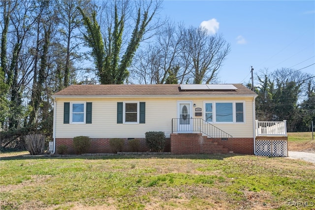 view of front of property featuring roof with shingles, solar panels, and a front yard