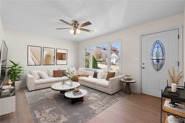 living area featuring a ceiling fan and wood finished floors