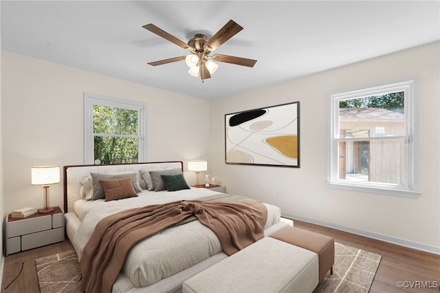 bedroom featuring ceiling fan, baseboards, and wood finished floors