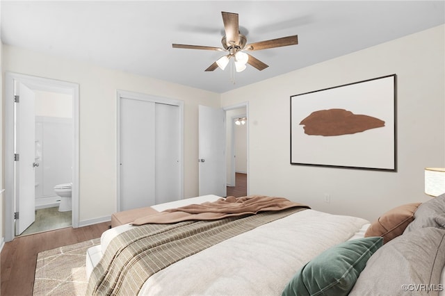 bedroom featuring ceiling fan, baseboards, wood finished floors, a closet, and ensuite bath