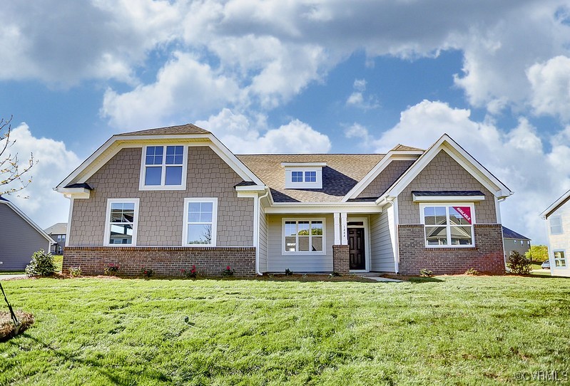 view of front facade featuring brick siding and a front lawn