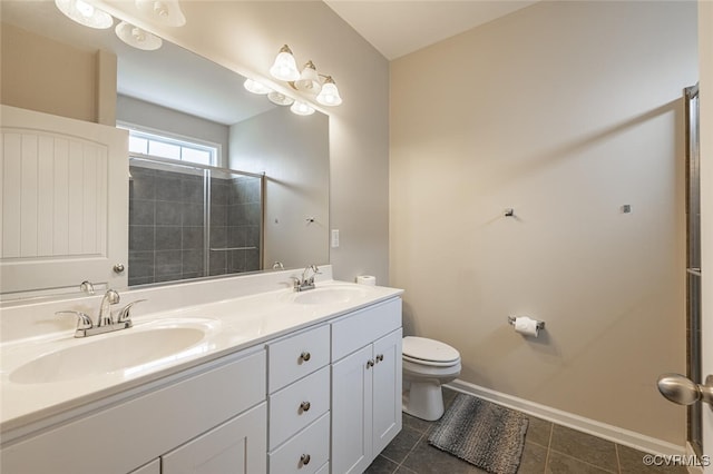 full bathroom with double vanity, toilet, baseboards, and a sink