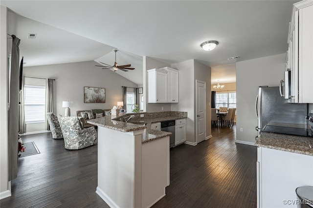 kitchen with dark wood-type flooring, light stone counters, stainless steel appliances, a peninsula, and white cabinets