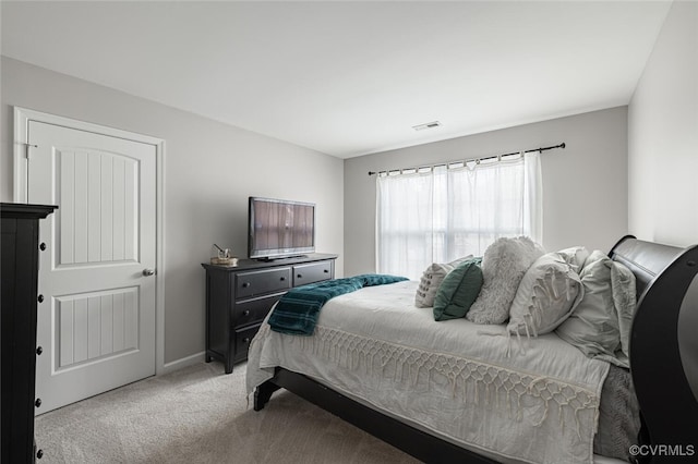 bedroom featuring visible vents and light carpet