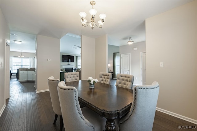 dining space with an inviting chandelier, baseboards, and dark wood-style flooring