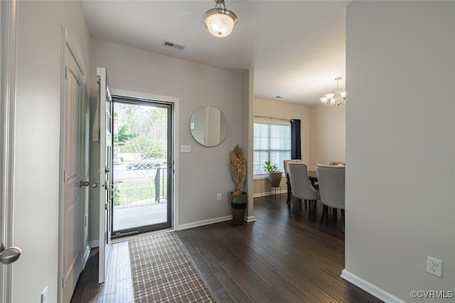 entrance foyer featuring a notable chandelier, visible vents, baseboards, and dark wood-style flooring