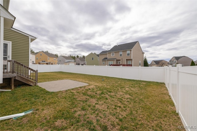 view of yard with a patio, a fenced backyard, and a residential view