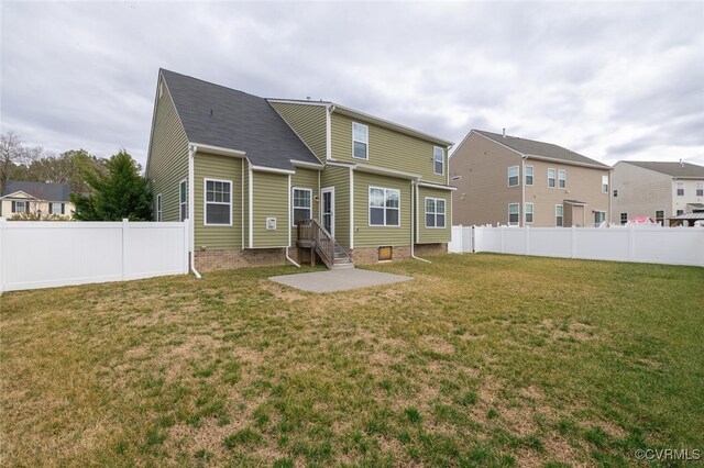 rear view of house with a lawn and a fenced backyard