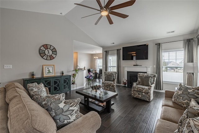 living area featuring visible vents, plenty of natural light, wood finished floors, and ceiling fan with notable chandelier