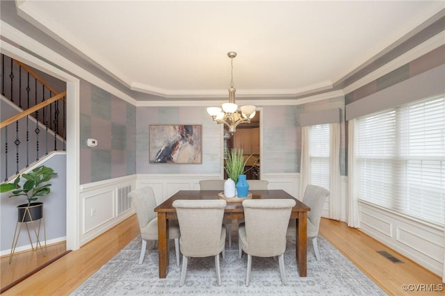 dining area with stairway, a notable chandelier, visible vents, and light wood-style flooring