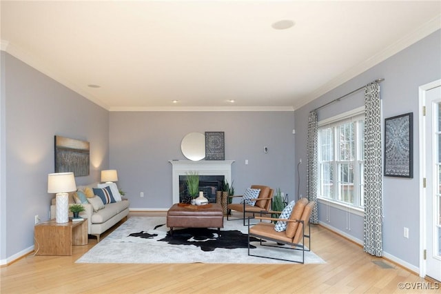 living area with light wood finished floors, crown molding, and baseboards