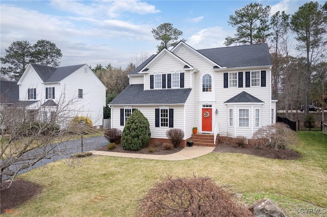 view of front of house with a front lawn, fence, and a shingled roof