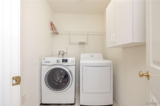 laundry area featuring cabinet space, independent washer and dryer, and baseboards