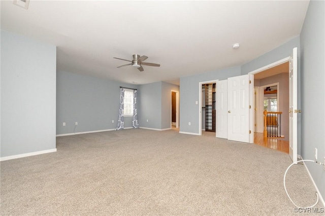 spare room with baseboards, carpet, and a ceiling fan