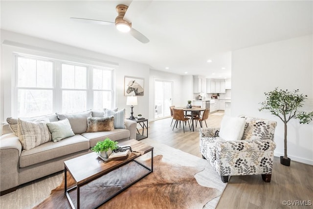 living area featuring recessed lighting, a ceiling fan, light wood-type flooring, and baseboards