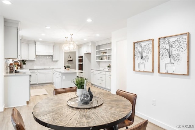 dining area with a notable chandelier, recessed lighting, baseboards, and light wood finished floors