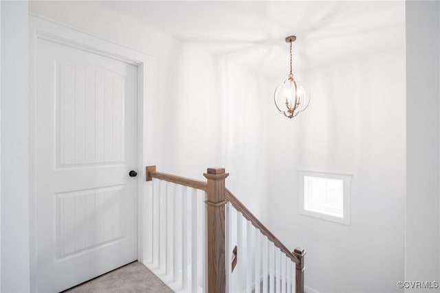 stairs featuring a notable chandelier