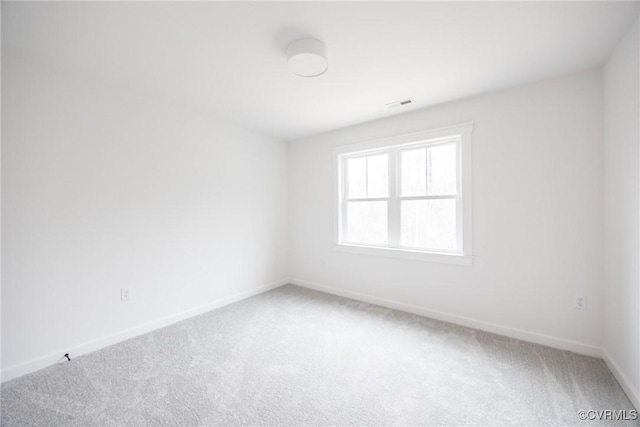 unfurnished room featuring light carpet, visible vents, and baseboards