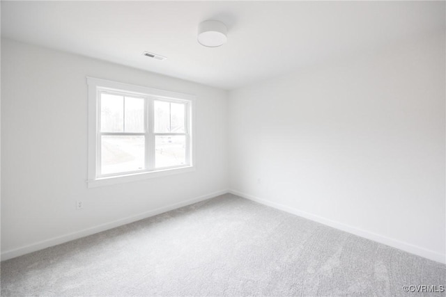 unfurnished room featuring light carpet, visible vents, and baseboards