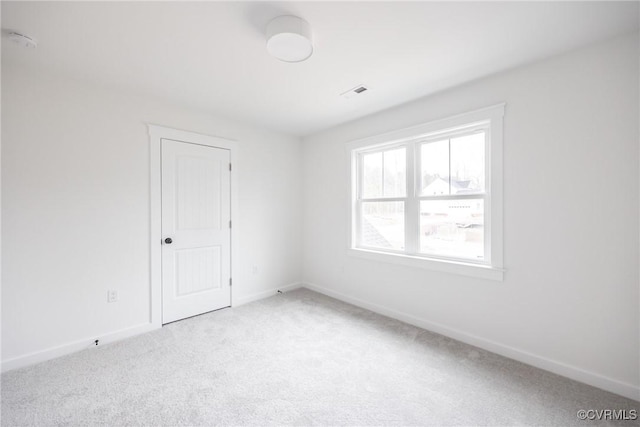 carpeted empty room with visible vents and baseboards