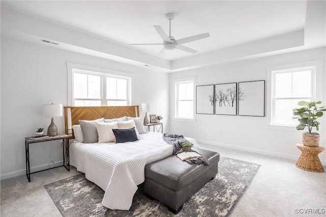 bedroom with visible vents, carpet flooring, baseboards, and a tray ceiling