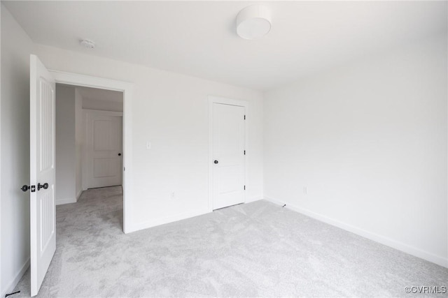 unfurnished bedroom with light colored carpet and baseboards