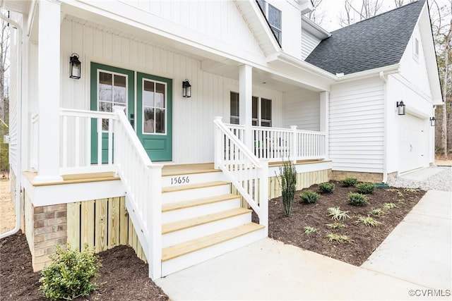 doorway to property featuring a porch, an attached garage, and roof with shingles