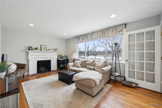 living room featuring a fireplace, recessed lighting, and wood finished floors