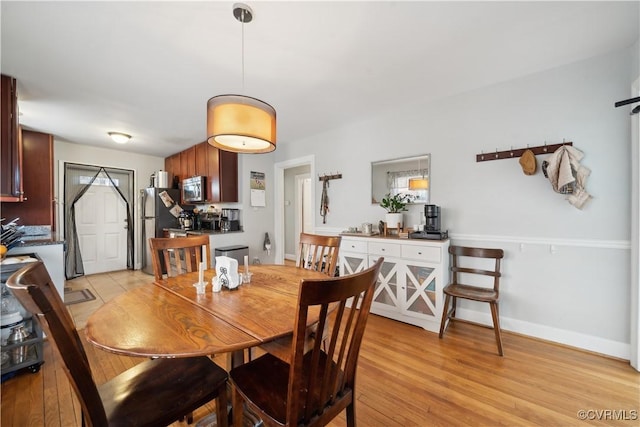 dining area with baseboards and light wood-style floors