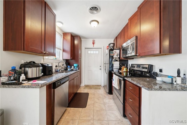 kitchen featuring a sink, stainless steel appliances, visible vents, and light tile patterned floors