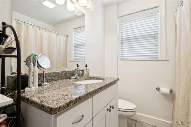 bathroom with tile patterned flooring, toilet, vanity, and baseboards