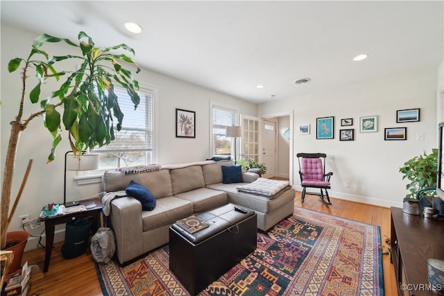 living room with visible vents, recessed lighting, baseboards, and wood finished floors