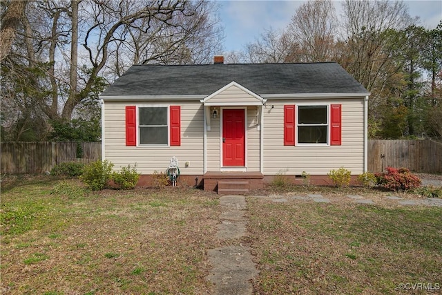 bungalow-style home featuring crawl space, a chimney, a front yard, and fence