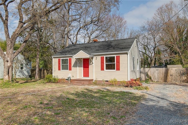 bungalow-style house featuring crawl space, a chimney, a front yard, and fence