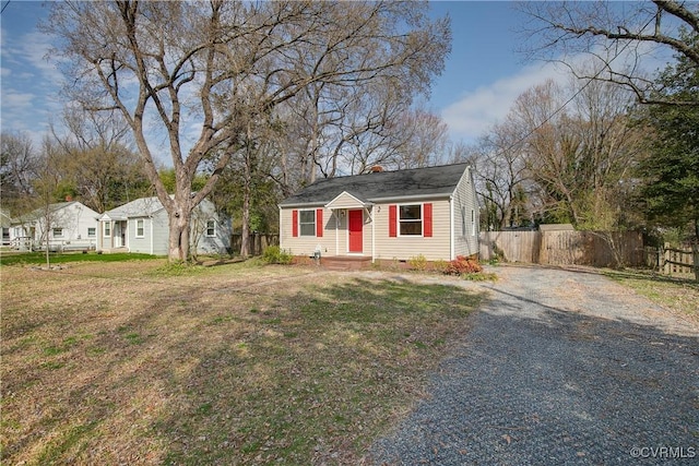 bungalow-style home with a front yard, fence, a chimney, and crawl space