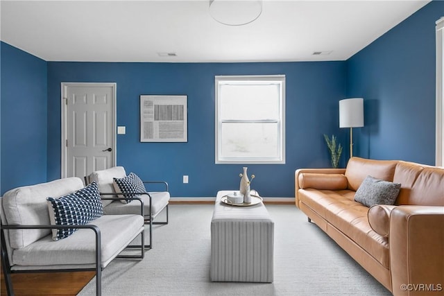 carpeted living room with visible vents and baseboards