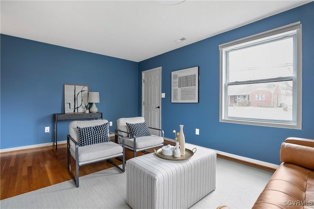 sitting room featuring visible vents, baseboards, and wood finished floors