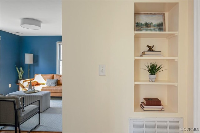 hallway with built in shelves and visible vents