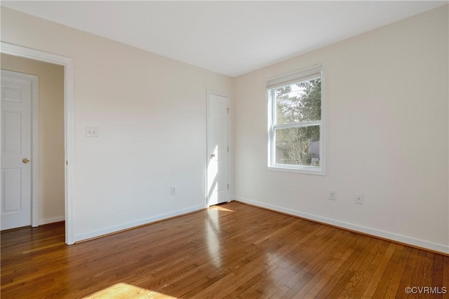 spare room with hardwood / wood-style flooring and baseboards