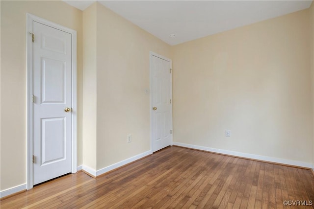 empty room featuring baseboards and wood-type flooring