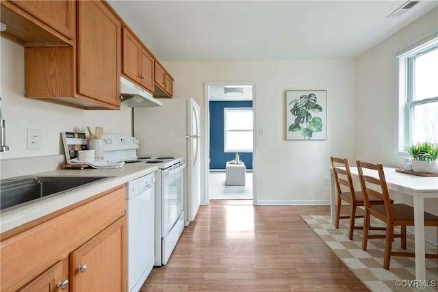 kitchen with white appliances, visible vents, light wood finished floors, baseboards, and light countertops