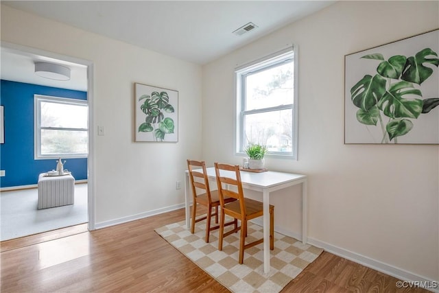 dining room featuring visible vents, baseboards, and light wood-style floors