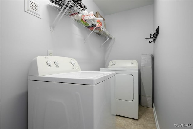 washroom with laundry area, washer and dryer, baseboards, and visible vents