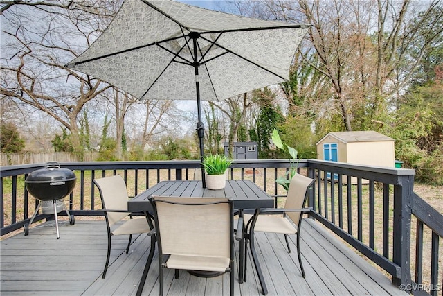 deck with a storage unit, outdoor dining area, area for grilling, and an outdoor structure