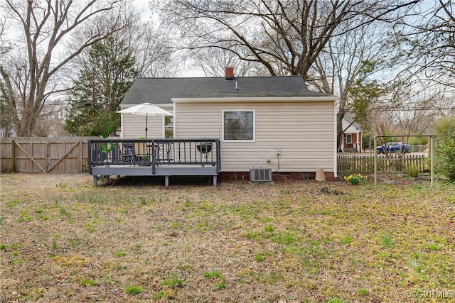 back of property with fence, central air condition unit, a chimney, a deck, and crawl space