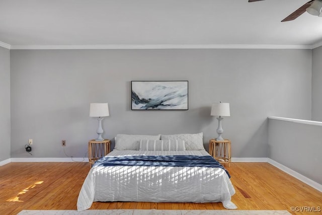 bedroom featuring a ceiling fan, crown molding, baseboards, and wood finished floors