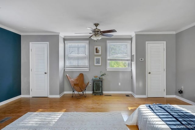 bedroom featuring ornamental molding, baseboards, and wood finished floors