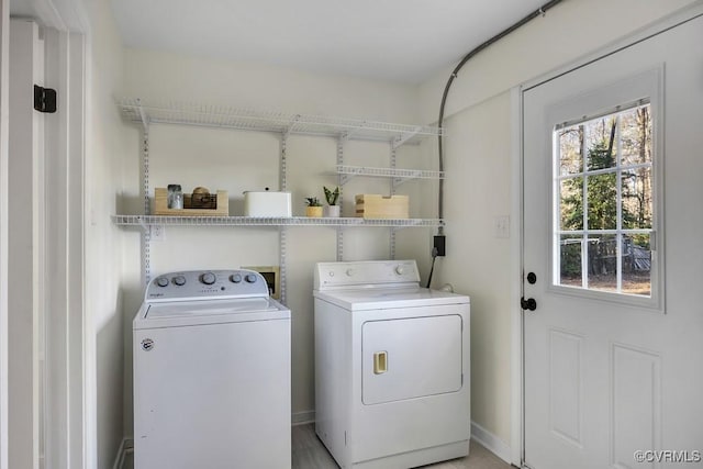 clothes washing area with washer and clothes dryer and laundry area